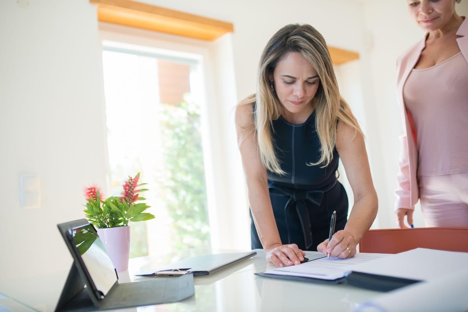 Une avocate signe un contrat à son bureau.